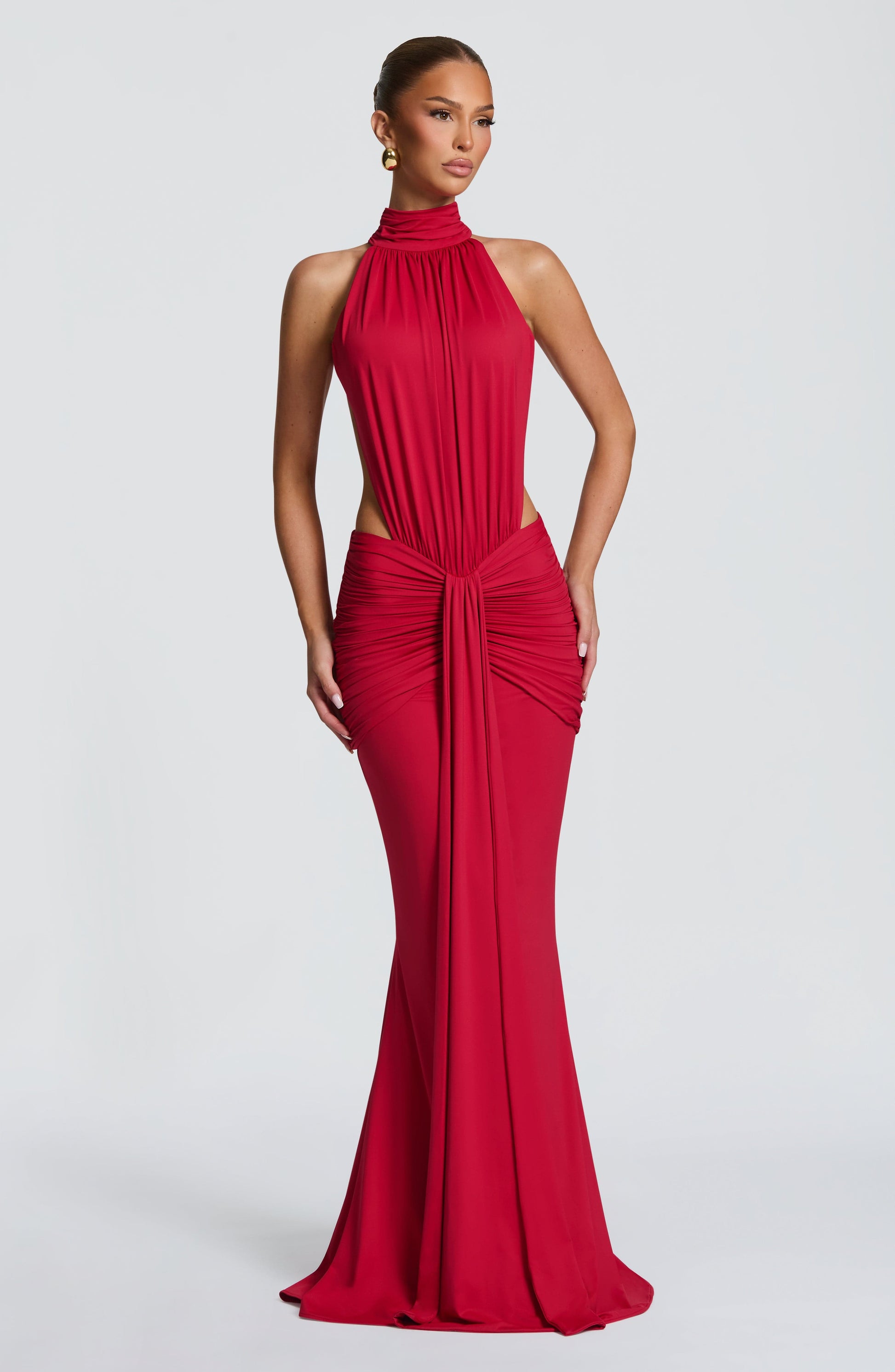 Front view of a red ruched halter maxi dress with high neckline and side cutouts