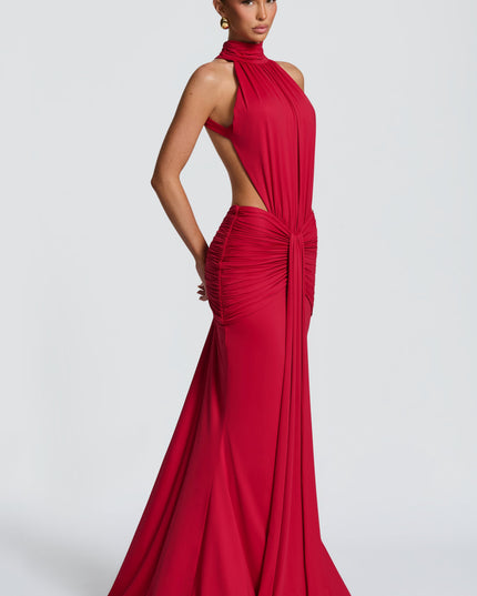 Side view of a red formal halter maxi dress showing ruched waist and flowing skirt