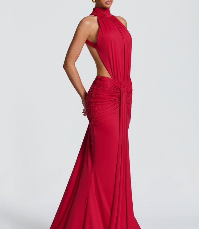 Side view of a red formal halter maxi dress showing ruched waist and flowing skirt