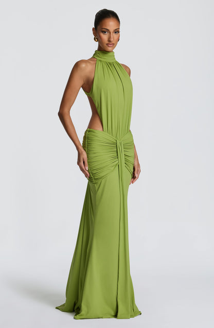 Side angle of green formal maxi dress showing ruched waist and flowing skirt