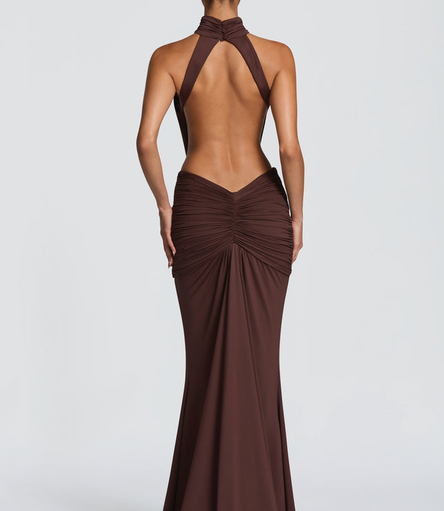 Side view of brown halter maxi dress with draped bodice and floor-length skirt