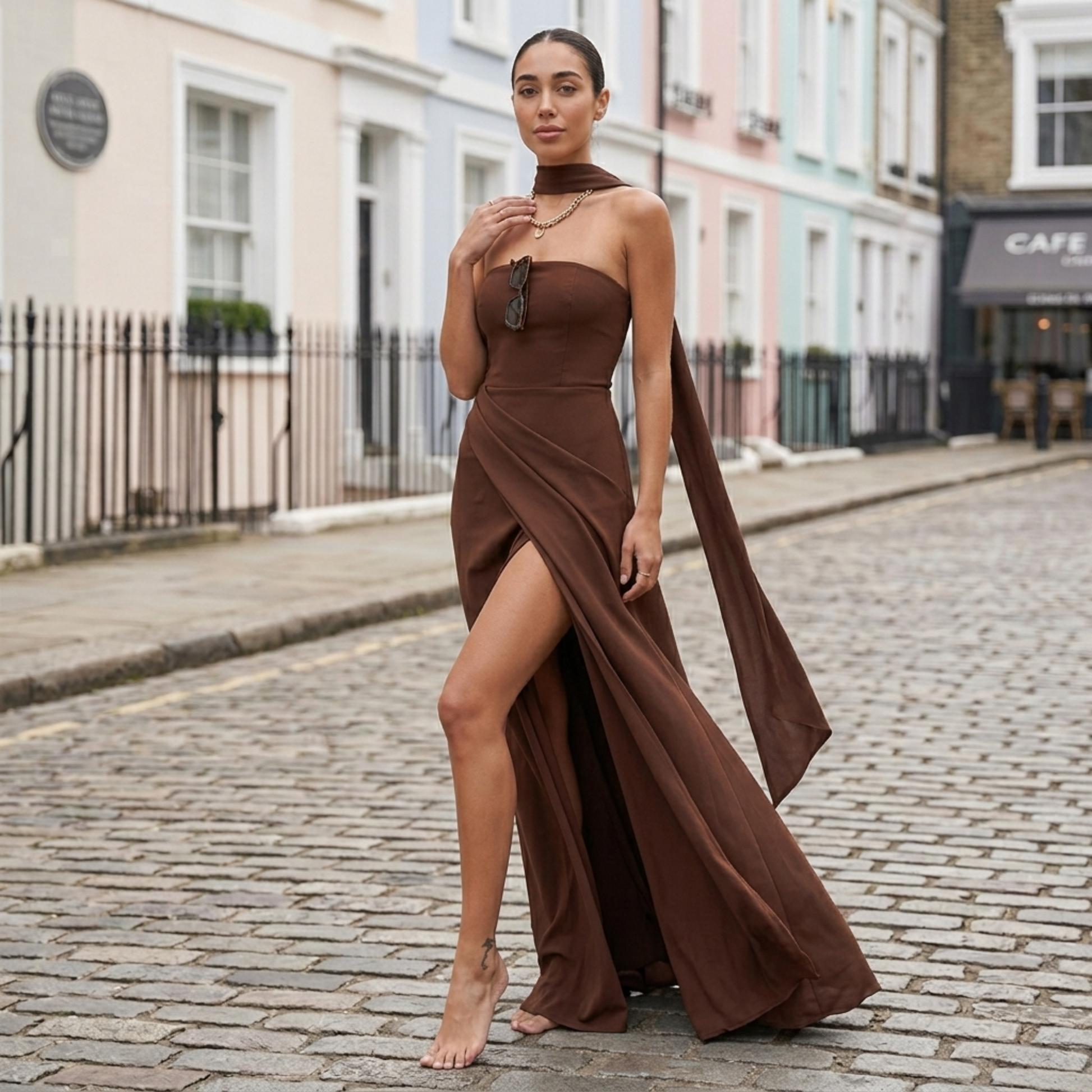 Brown strapless asymmetric maxi dress with draped scarf and thigh-high slit