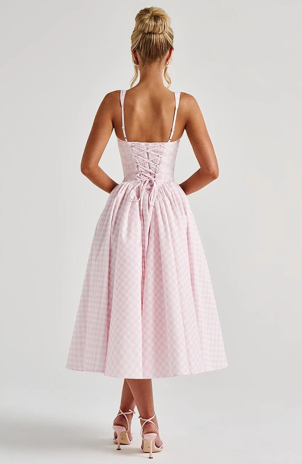 Back view of pink gingham midi dress showing lace-up corset detail