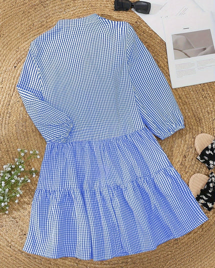 Blue gingham V neck mini dress laid flat with tiered skirt and long puff sleeves