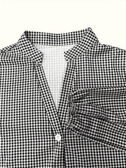 Close-up of black gingham V neck mini dress with collar, button front, and sleeve cuff