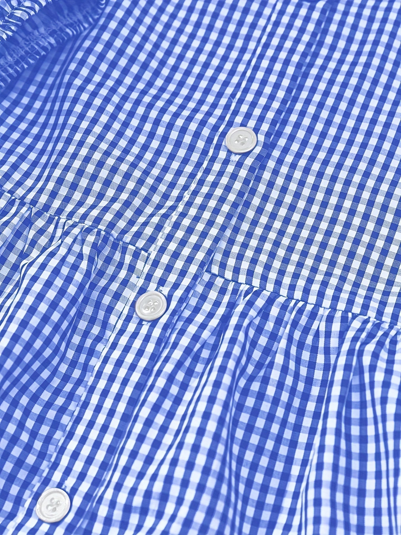 Close-up of blue gingham dress fabric with button front and gathered tier seam