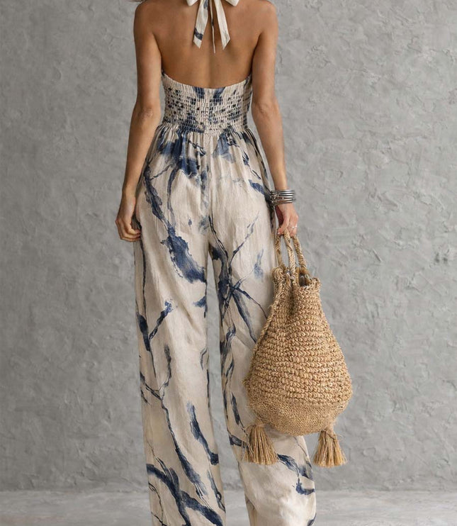Back view of cream navy printed halter jumpsuit with smocked waist and wide leg pants