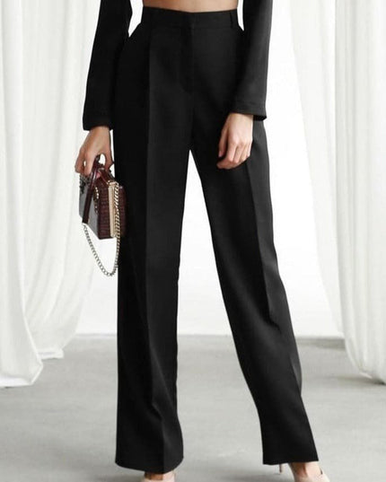 Black high waisted wide leg linen pants paired with a fitted long sleeve top and mini bag