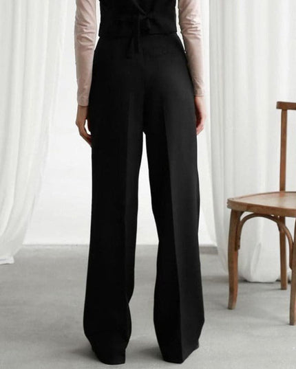 Back view of black high waisted wide leg linen pants with a tailored loose fit
