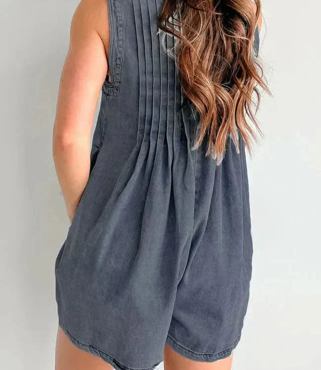 Back view of dark denim romper for women with gathered back pleats and sleeveless mini shorts