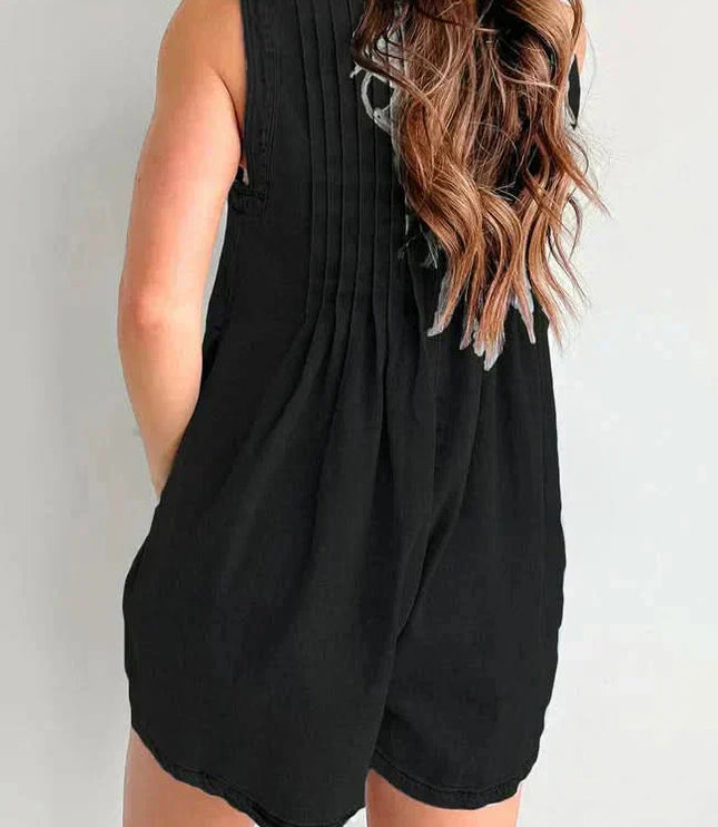 Back view of black casual denim romper with pleated back detail and relaxed sleeveless cut