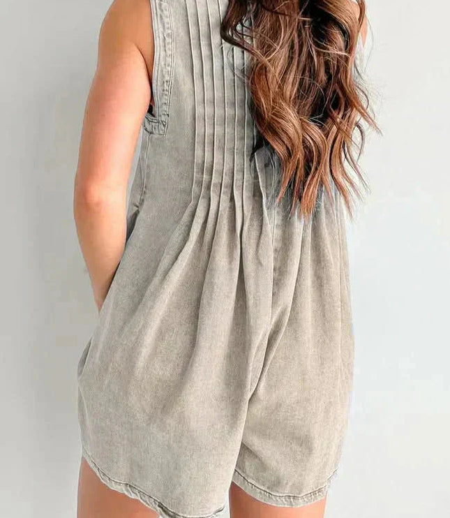 Back view of beige women's denim romper with soft pleats, sleeveless shoulders, and mini length