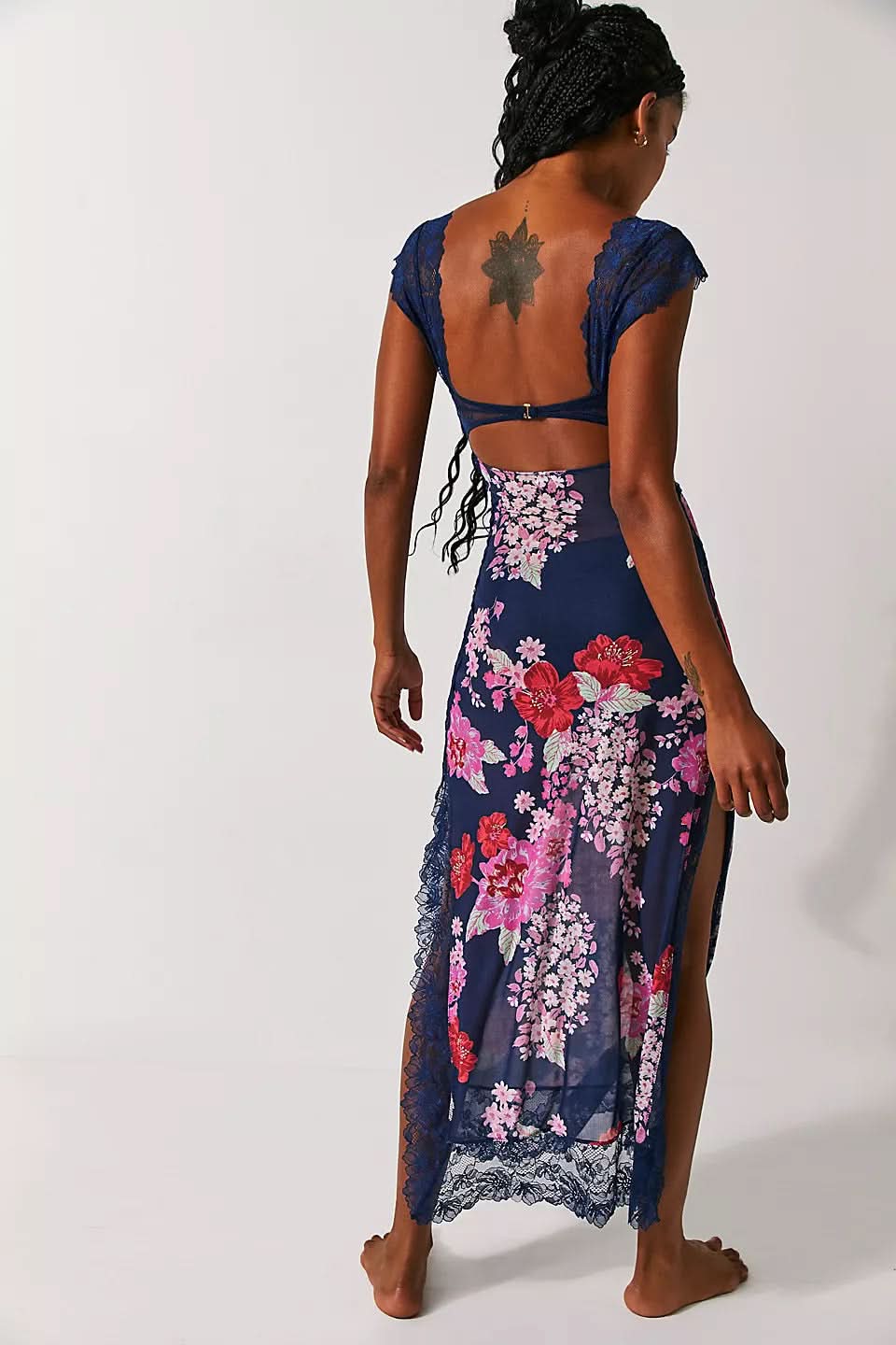 Back view of navy floral midi dress with open back, lace sleeves, and side slit