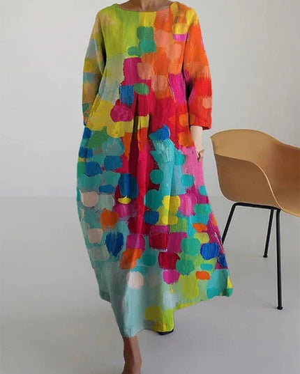 Flowy long sleeve women's maxi dress with abstract print in yellow, orange, pink, and turquoise