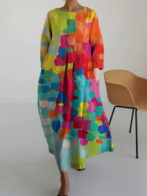 Flowy long sleeve women's maxi dress with abstract print in yellow, orange, pink, and turquoise