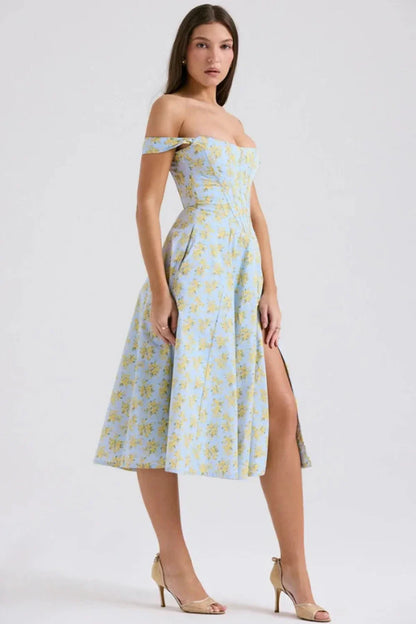 Side view of a floral off shoulder midi dress with fitted bodice and front slit