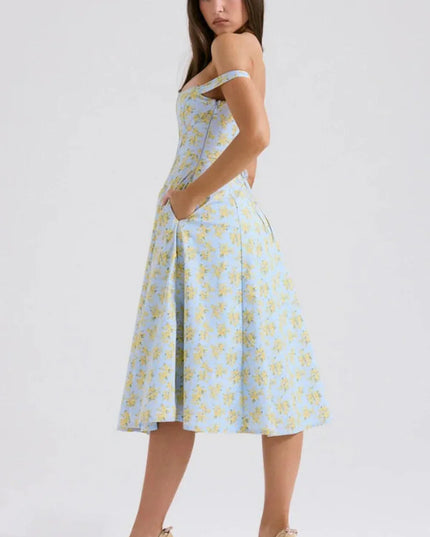 Three-quarter back view of a blue floral midi dress with off shoulder sleeves and slit