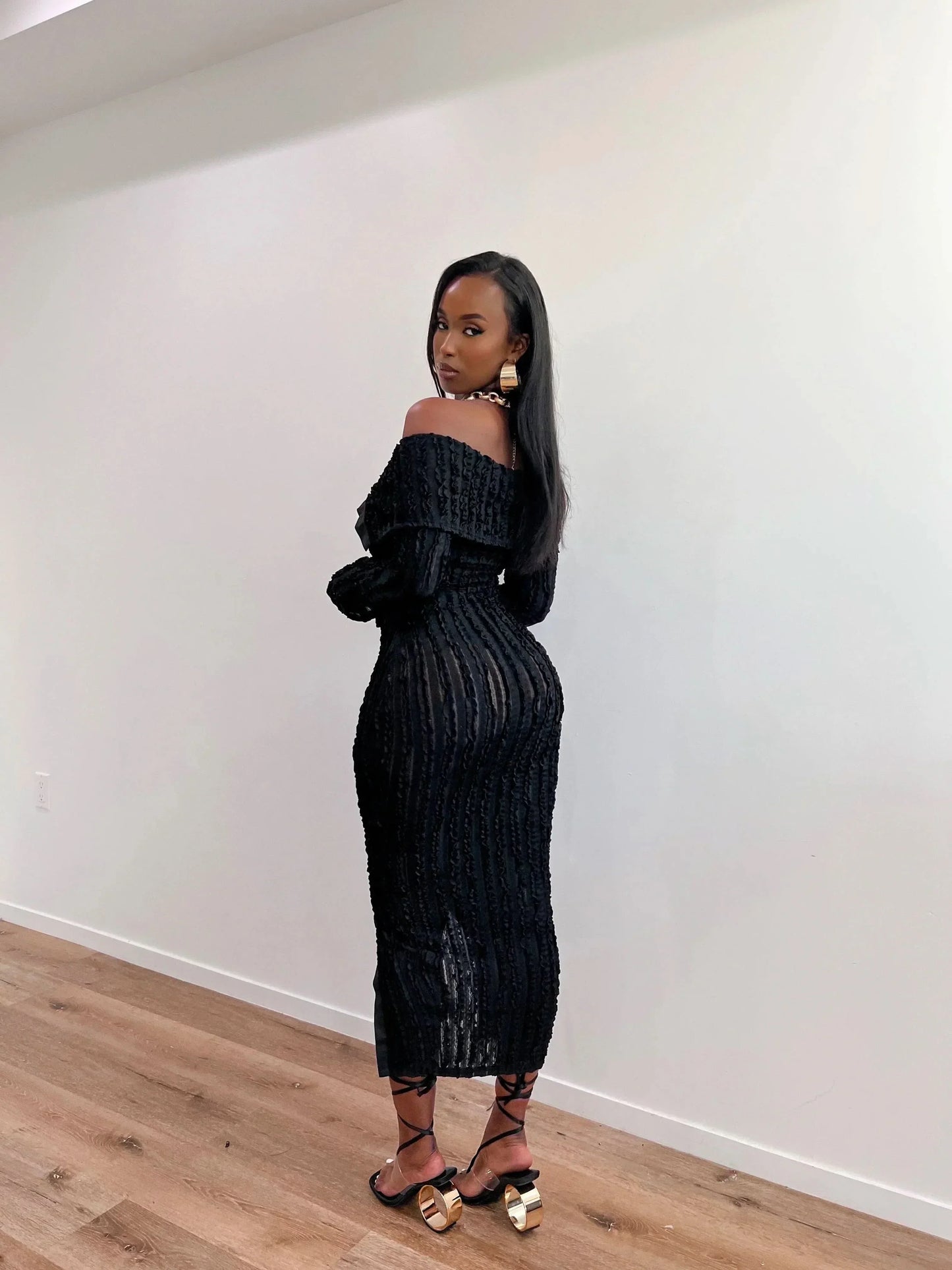 Black off shoulder midi dress with long sleeves, textured ribbed detail, and front slit