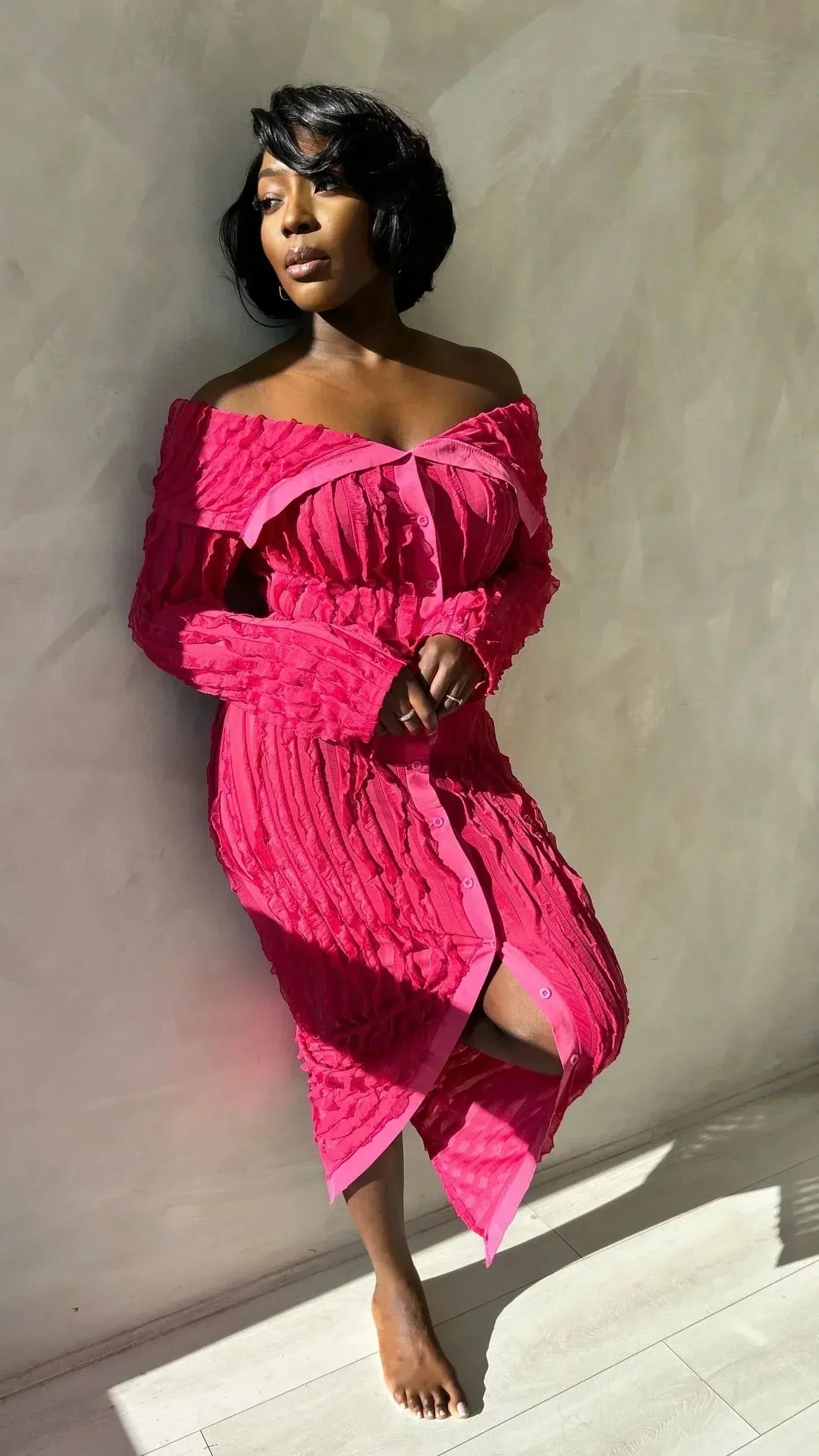 Bright pink off shoulder midi dress with long sleeves, button front, and textured fabric