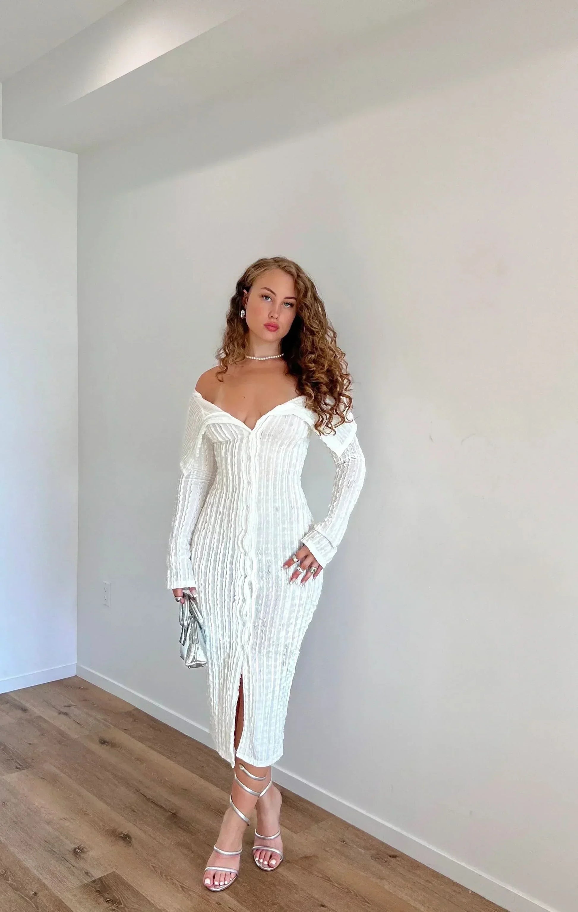White off shoulder midi dress with long sleeves, ribbed texture, and front slit