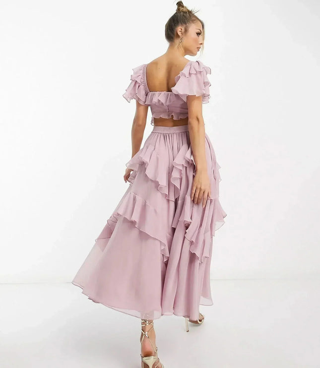 Side view of blush pink midi dress showing off-shoulder ruffles and cascading layered skirt