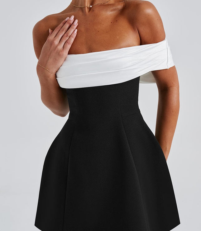 Close front view of black mini dress showing white off shoulder wrap detail and fitted waist