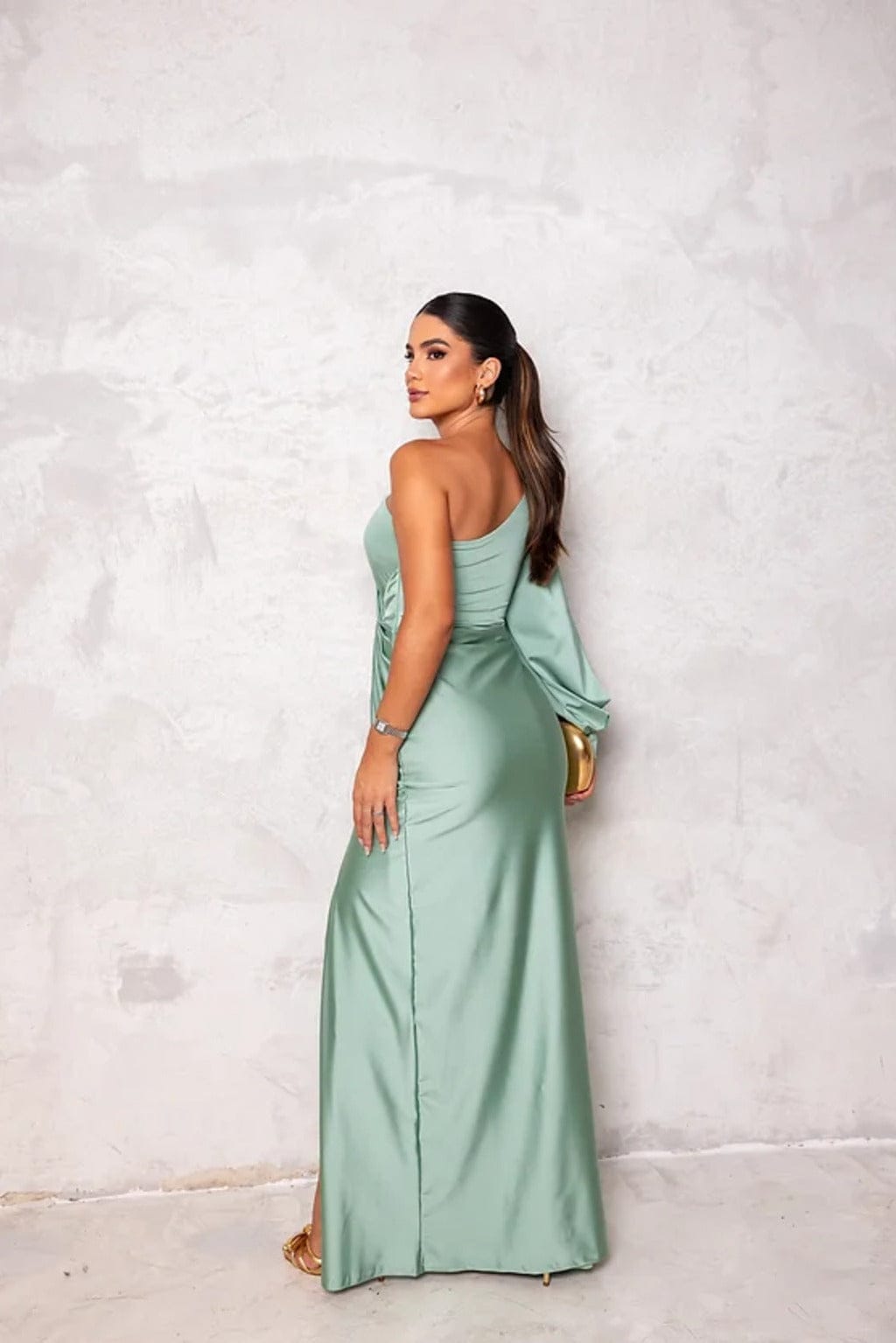 Back view of sage green satin maxi dress with one shoulder and flowing skirt