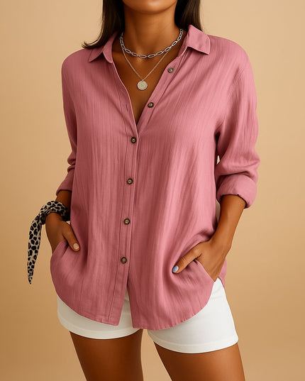 Pink linen button down shirt with long sleeves, front pockets, and white shorts