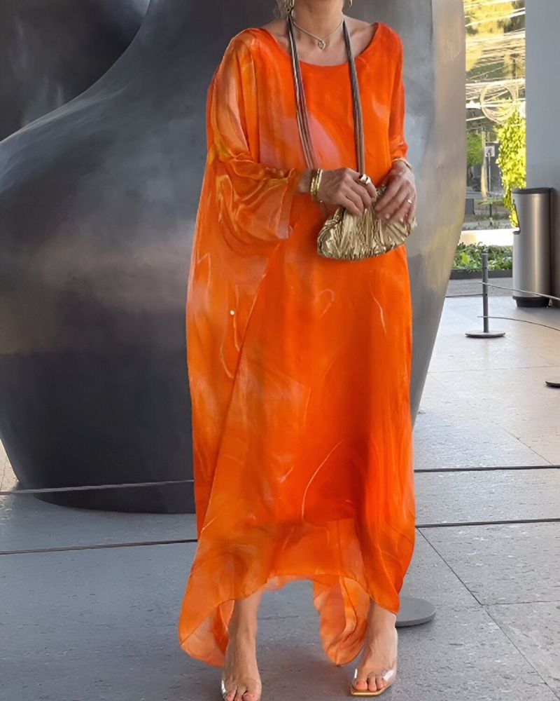 Bright orange abstract print maxi dress with sheer sleeves and breezy resort style