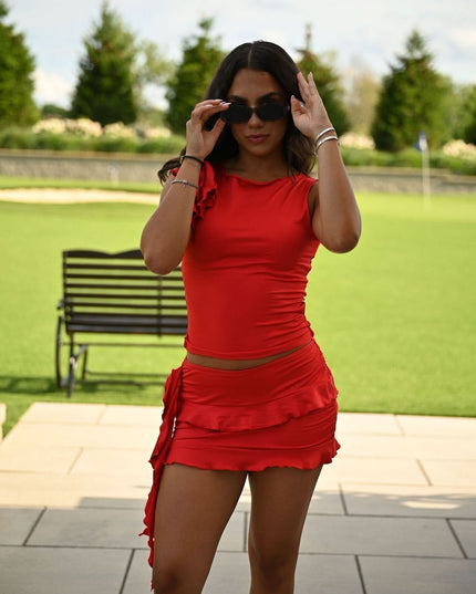 Red summer dress with ruched waist and ruffle mini skirt, front view with sunglasses
