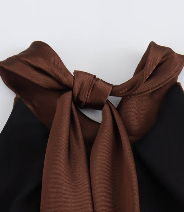 Close-up of satin halter top neckline on brown midi dress with tied straps and soft sheen