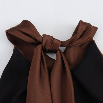 Close-up of satin halter top neckline on brown midi dress with tied straps and soft sheen