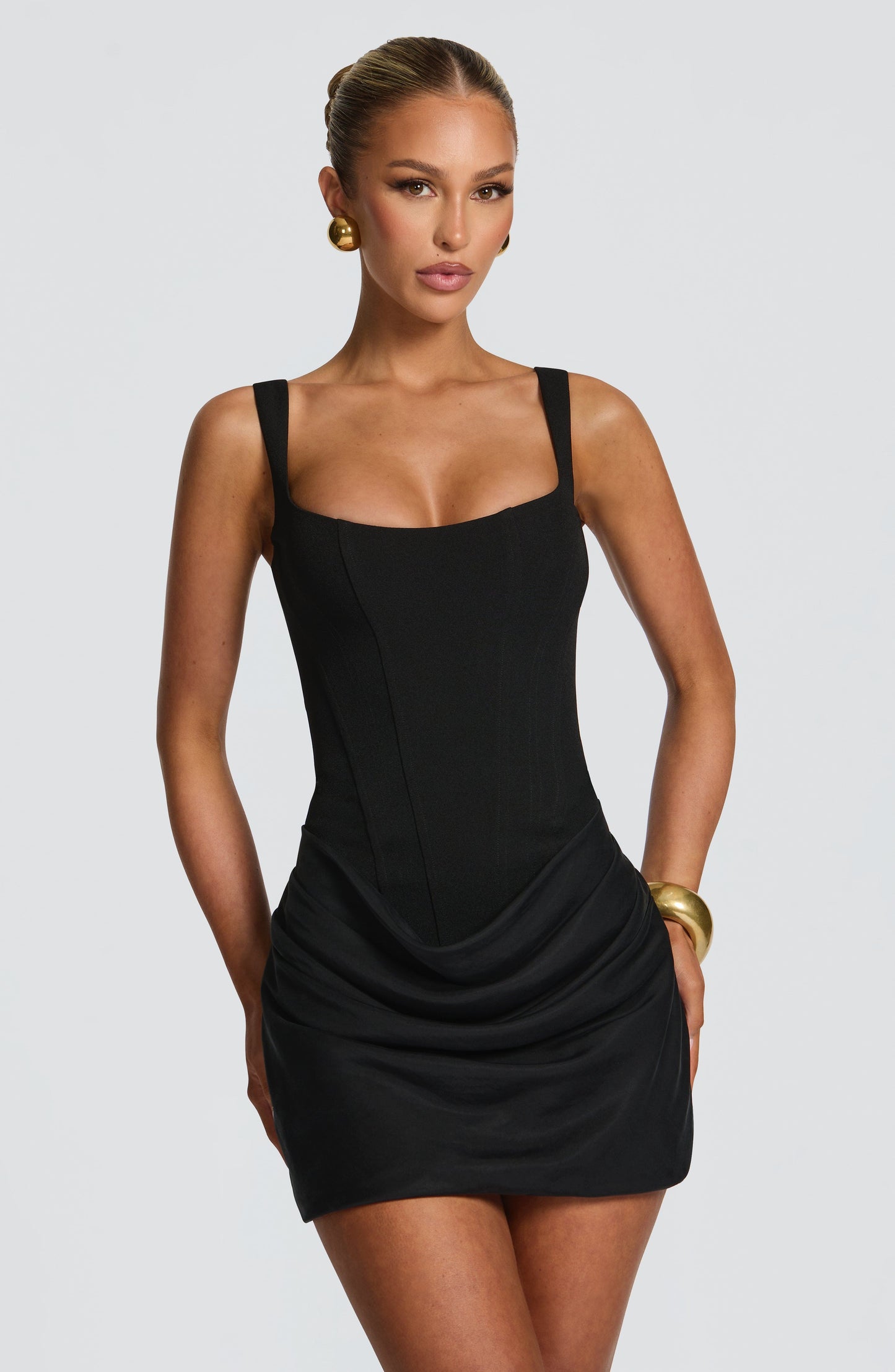 Black satin mini dress with square neckline, fitted silhouette, and draped skirt detail