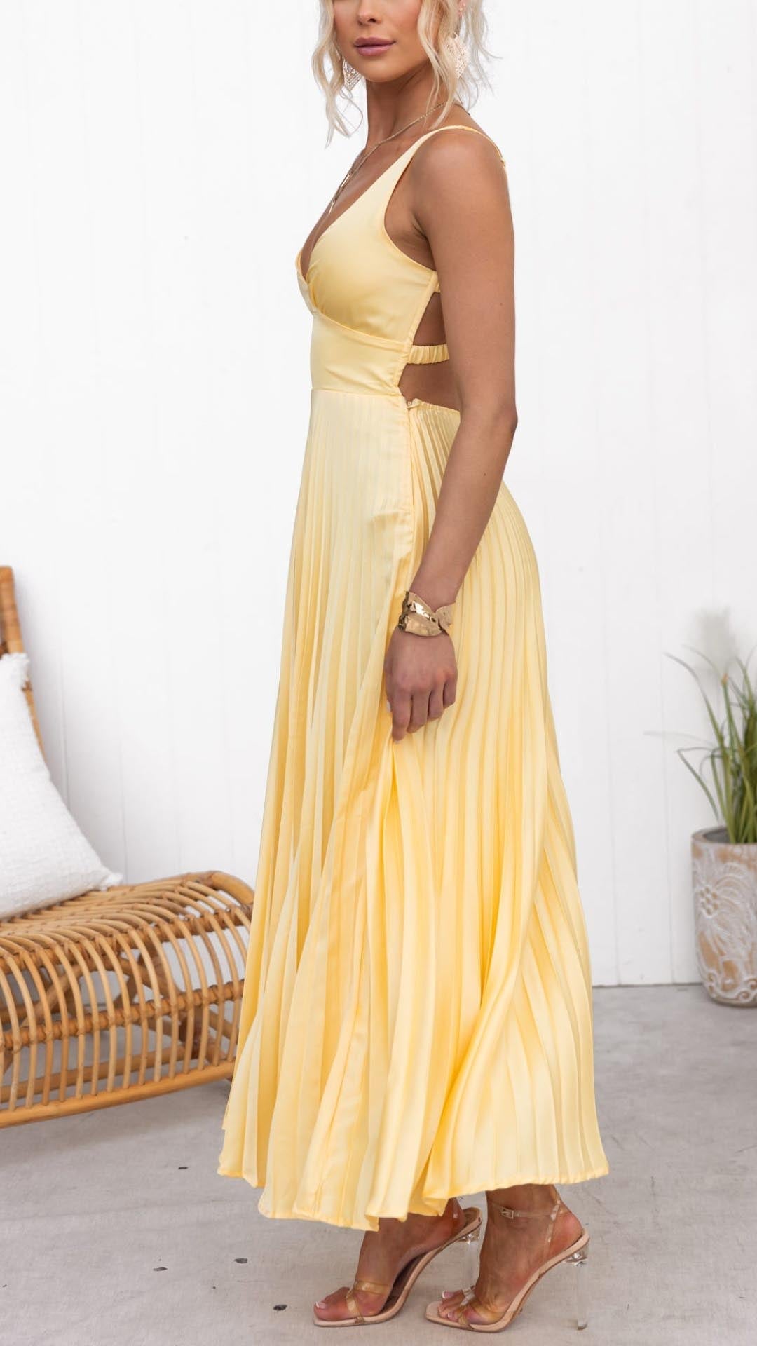 Side view of pleated yellow summer dress with V neck and open back detail
