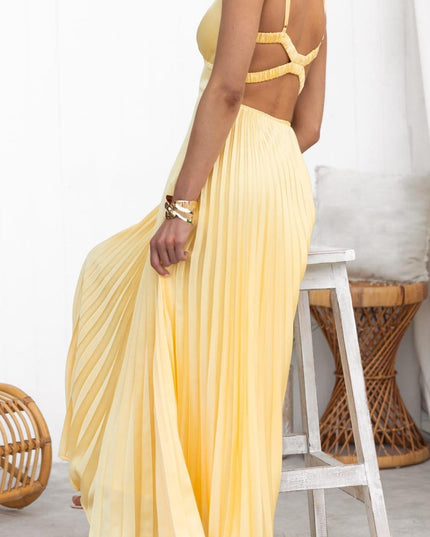 Back view of yellow maxi dress with crisscross strap detail and pleated skirt