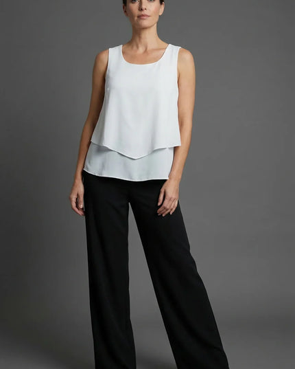White sleeveless layered top with black wide leg pants in a minimalist summer co ord set