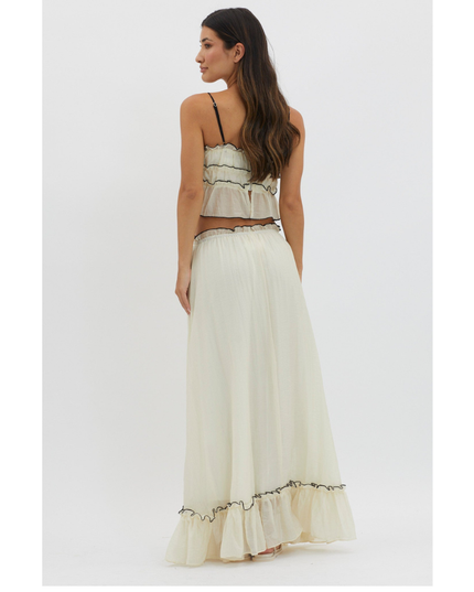 Back view of cream summer maxi skirt set with black trim and ruffled hem on white background