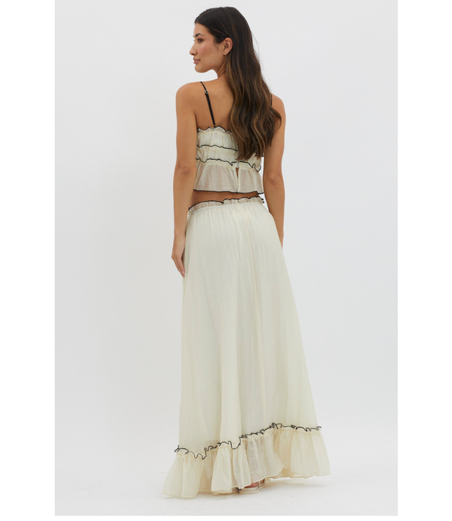 Back view of cream summer maxi skirt set with black trim and ruffled hem on white background