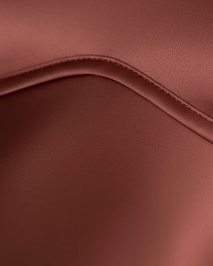 Close-up of rust satin maxi dress fabric showing smooth sheen and curved seam detail