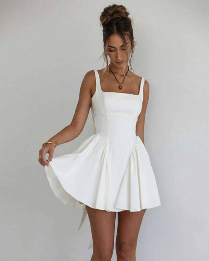 White square neck mini dress with fitted bodice, flared skirt, and open back bow detail