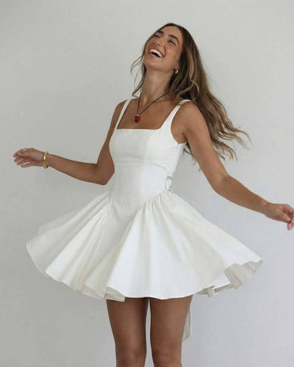 White mini dress with square neck, fitted waist, and soft pleated skirt for summer dress styling