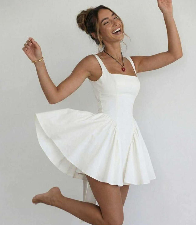 Woman wearing white square neck mini dress twirling to show full flared skirt and open back