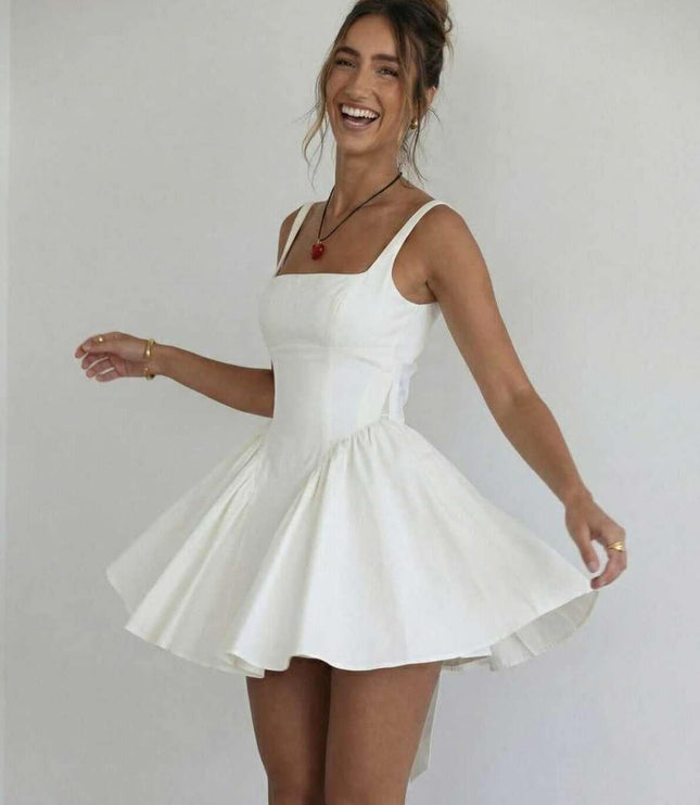 White wedding guest mini dress with square neckline and voluminous skirt in a playful pose