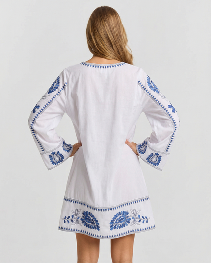 Back view of white summer dress with blue embroidery, long sleeves, and mini length