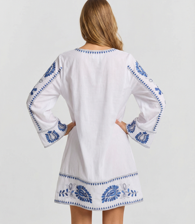 Back view of white summer dress with blue embroidery, long sleeves, and mini length