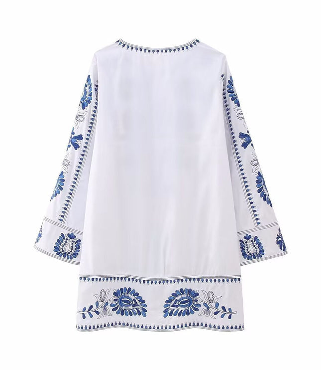 Back view of white mini dress with blue embroidered border details and relaxed fit