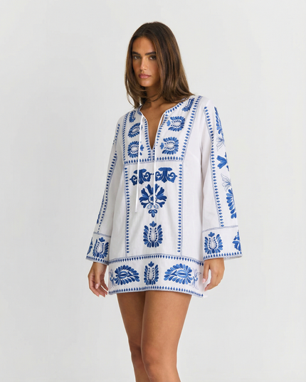 White summer mini dress with blue embroidered floral pattern and long bell sleeves
