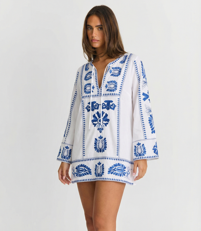 White summer mini dress with blue embroidered floral pattern and long bell sleeves