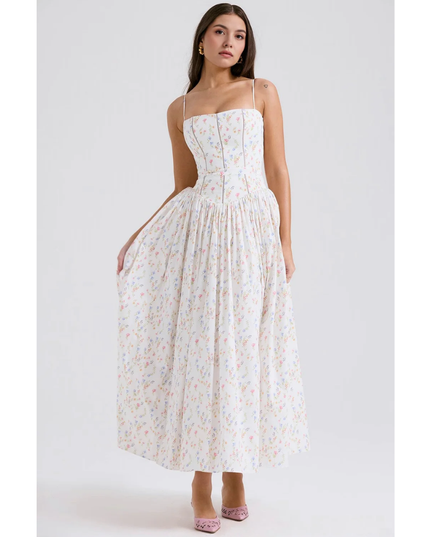 White floral maxi dress with gathered waist, thin straps, and flowing skirt