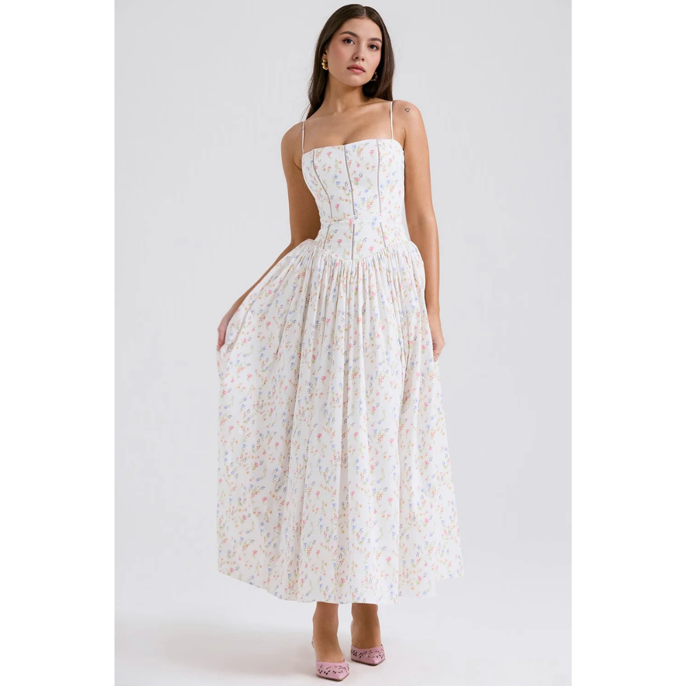 White floral maxi dress with gathered waist, thin straps, and flowing skirt